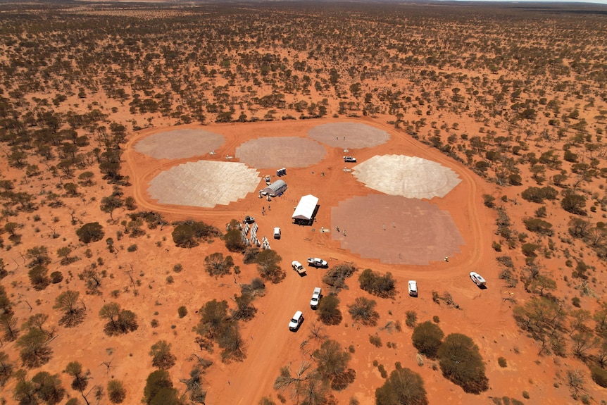 An aerial drone shot of a facility under construction in outer WA, with lots of red dirt around. 